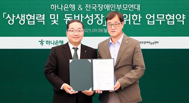 이호성 하나은행장(사진 왼쪽)이 윤종술 전국장애인부모연대 회장(사진 오른쪽)과 협약서를 들고 기념촬영을 하고 있다. (하나은행 제공)
