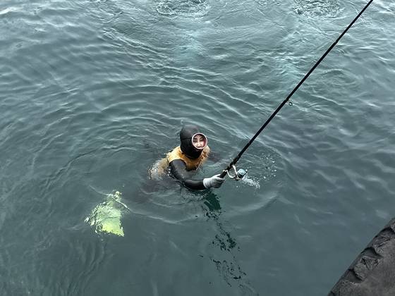 8일 오후 2시 제주시 조천읍 조천포구에서 해녀가 수거한 낚시대를 뭍으로 전달하고 있다. 최충일 기자