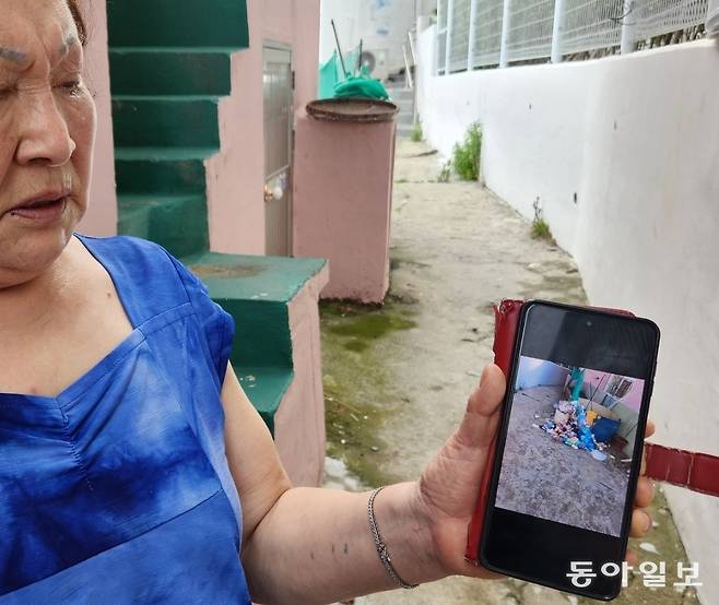 감천문화마을 주민이 관광객들이 버리고 간 쓰레기 사진을 보여주며 생활 불편을 호소하고 있다. 김화영 기자 run@donga.com