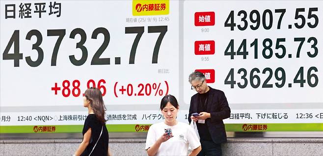 9일 일본 도쿄의 한 증권사 앞에서 시민들이 주가를 확인하고 있다. 닛케이225지수는 장중 한때 44,185까지 오르며 사상 최고치를 기록했다. 로이터연합뉴스