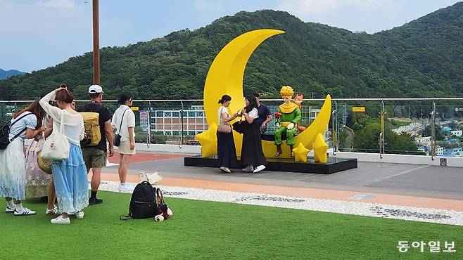 부산 사하구 감천문화마을 감내별마루체육센터 옥상에 설치된 어린 왕자 조형물 앞에서 외국인 관광객들이 기념 촬영을 하기 위해 줄을 서 있다.
김화영 기자 run@donga.com