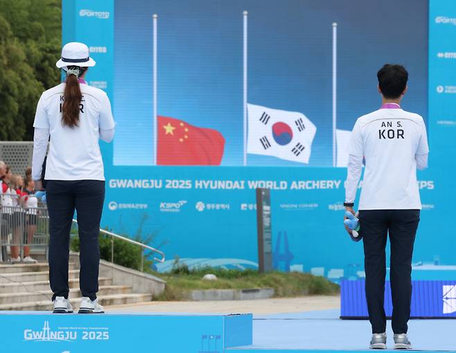 12일 광주 동구 국립아시아문화전당 5·18민주광장에서 열린 2025 세계양궁선수권대회 리커브 여자 개인전 시상식에서 강채영과 안산이 애국가가 나오자 태극기를 바라보고 있다. 연합뉴스