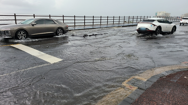 오늘(15일) 낮 도로 침수와 싱크홀 등이 발생한 제주시 용담 해안도로 (제주소방안전본부 제공)