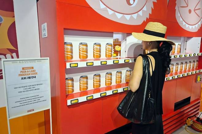 지난 12일 서울시 성동구 성수동에서 열린 팝마트의 '라부부의 수상한 편의점' 팝업스토어에 마련된 자판기 포토부스에서 방문객이 사진을 찍고 있다. 최호경 기자