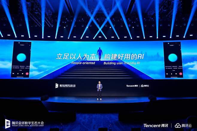16일 오전 텐센트가 주최한 ‘글로벌 디지털 에코 시스템 서밋(DES)’에서 다우손 퉁 텐센트 부사장은 'AI 응용 번영 계획'을 발표했다. 이 계획은 기업들과 협력을 강화하는 'AI 공동 개발 캠프(共創營)'와 대학 및 연구기관과 손잡는 'AI 100개 학교행(百校行)'을 포함한다. 행사장 스크린에는 '사람을 근본으로, 쓰기 좋은 AI를 만들자'는 문구가 적혀 있다./텐센트