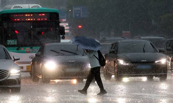 16일 오후 경기 수원시 영통구의 한 도로에서 시민이 우산을 쓰고 걸어가고 있다. 뉴스1