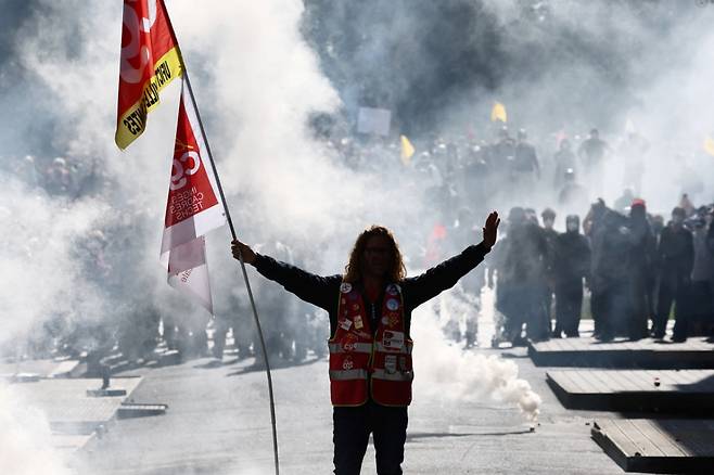 CGT 노동조합기를 든 시위대가 프랑스 낭트에서 열린 집회에 참가해 프랑스 경찰과 충돌하는 동안 최루탄 속에 서 있다. 이 시위는 전국적인 파업 과 정부와 차기 예산 삭감에 반대하는 시위의 일환이다. //로이터=뉴스1