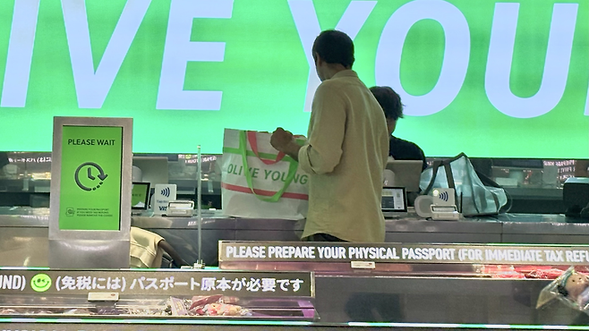 17일 올리브영 서울 명동 타운점을 찾은 한 외국인 관광객이 타포린백에 구매한 물건을 옮겨담고 있다. 박연수 기자