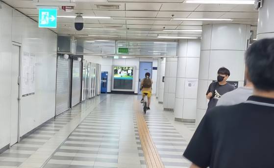 18일 오전 서울지하철 1호선 동대문역 환승통로에서 한 시민이 자전거를 탄 채 이동하고 있다. 사진 독자