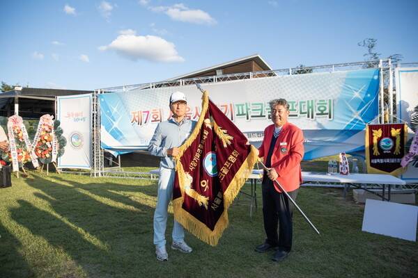 이영우 서울시파크골프협회장이 송파구협회 선수에게 우승기를 전달하고 있다.