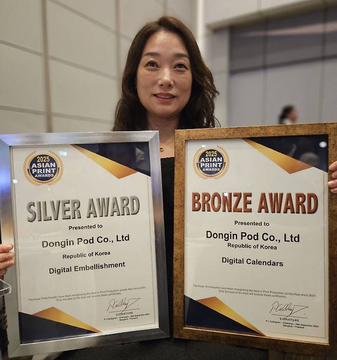 최은서 동인피오디 대표가 지난 19일 태국 방콕에서 열린 '아시안 프린트 어워드(Asian Print Awards) 2025'에서 디지털 장식 부문(Digital Embellishment) 은상과 디지털 캘린더 부문(Digital Calendars) 동상을 수상한 뒤 기념촬영하고 있다. 동인피오디는 이번 시상식에 앞서 대전의 마스코트인 꿈씨패밀리(꿈돌이)를 활용한 2026년 캘린더를 2개 부문에 출품했다. /동인피오디 제공