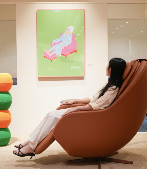 세라젬 모델이 세라젬 안마의자에 앉아 예술 작품을 감상하고 있다.