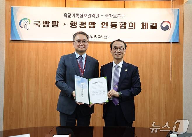 25일 충남 계룡시 육군기록정보관리단에서 이승우 국가보훈부 보상정책국장과 주용선 육군 기록정보관리단장이 국가유공자 등록심사 단축을 위한 전산망 연동 합의서에 서명후 기념촬영을 하고 있다. (국가보훈부 제공)