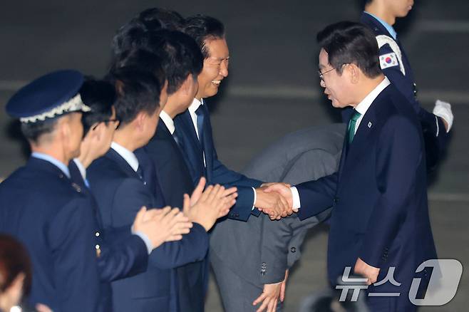 이재명 대통령이 26일 미국 뉴욕 유엔총회 일정을 마치고 경기도 성남 서울공항을 통해 귀국해 환영나온 정청래 더불어민주당 대표와 악수하고 있다. 2025.9.26/뉴스1 ⓒ News1 이광호 기자