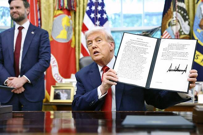 도널드 트럼프 미국 대통령이 25일(현지시간) 백악관 집무실에서 틱톡 미국 사업권 인수를 허용하는 행정명령에 서명한 문서를 들어 보이고 있다. 트럼프 대통령은 서명식에서 "한국의 대미 투자금 3500억달러는 선불"이라고 말했다. 로이터연합뉴스