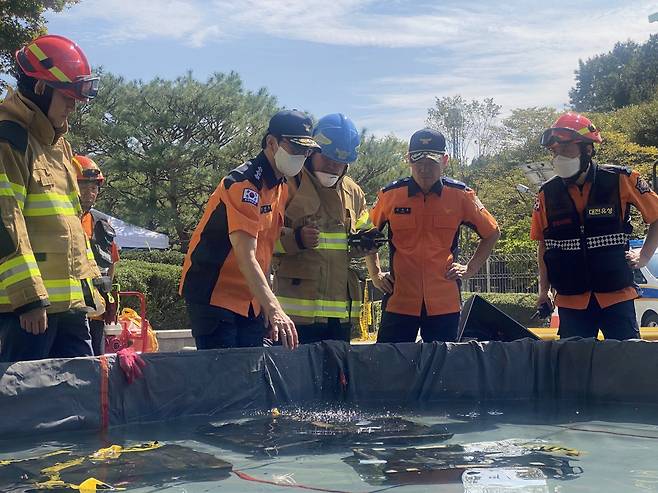 김승룡 소방청장 직무대행이 27일 국가정보자원관리원 화재 현장에서 소화수조에 담긴 불에 탄 리튬이온 배터리를 살펴보고 있다. (소방청 제공) 2025.9.27 뉴스1