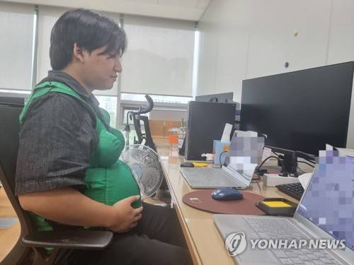 남자 대학생의 임신부 체험 (서울=연합뉴스) 서윤호 인턴기자 = 지난 22일 종로구 연합뉴스 편집국에서 임산부 체험복을 입고 오후 업무를 진행했다. 2025.09.27