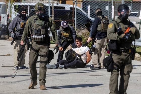 도널드 트럼프 미국 대통령이 범죄 예방을 지원하기 위해 연방 법 집행 기관의 주둔을 늘리라고 지시한 지난 26일(현지시간) 일리노이주 브로드뷰에서 연방 요원들이 브로드뷰 ICE 처리 시설 밖에서 한 시위대를 구금하고 있다. 로이터=연합뉴스