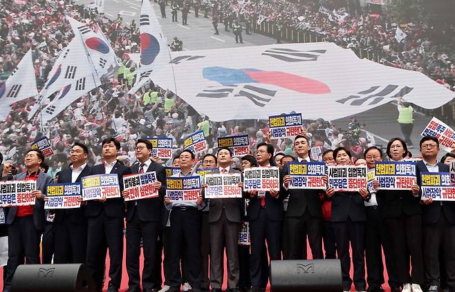 국민의힘 장동혁 대표와 송언석 원내대표를 비롯한 의원들이 28일 서울 시청역 7, 8번 출구 앞 대로에서 열린 '사법파괴 입법독재 국민 규탄대회'에서 '사법파괴 입법독재 민주당은 중단하라'라고 적힌 손피켓을 들고 있다.
