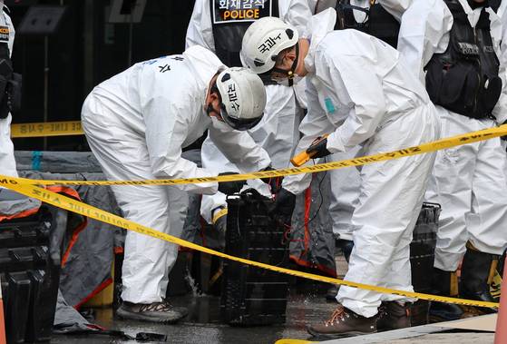 29일 오전 대전 유성구 국가정보자원관리원(국정자원) 화재 현장에서 경찰 관계자들이 불이 붙었던 무정전·전원 장치(UPS)용 리튬이온배터리 상태를 확인하고 있다. 연합뉴스