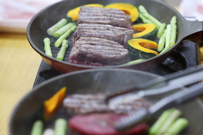 우리밥연대 ‘풀코스’의 대표 메뉴인 한우 안심 스테이크가 구워지고 있다. 장기 농성장에만 대접하는 ‘풀코스’ 요리는 샐러드, 파스타, 스테이크는 고정 메뉴이고 나머지는 그때그때 바뀐다. 죽, 떡볶이, 비빔국수, 밥과 맑은탕 등이 나간 적도 있다.