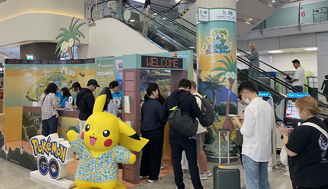 제주공항 도착장에 꾸려진 ‘포켓몬 원더 아일랜드 in Jeju’ 홍보존. 피카츄가 손님을 맞이하고, 여행객들은 길게 줄을 서면서 공항 로비는 순식간에 축제의 무대로 바뀐다.