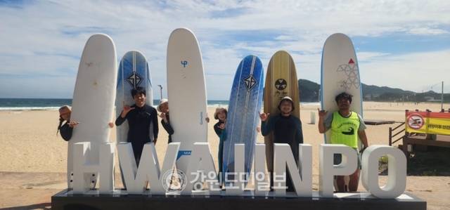▲ 우리나라 최북단에 위치한 화진포 서프스토리를 찾은 서퍼들이 화진포 해수욕장 포토 존에서 즐거운 표정을 지으며 서핑을 준비하고 있다.