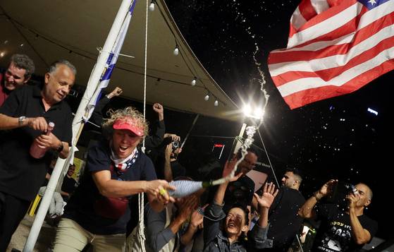 도널드 트럼프 미국 대통령이 8일(현지시간) 이스라엘과 하마스가 휴전 1단계에 합의했다고 발표한 뒤 이스라엘 텔아비브의 '인질 광장'에서 사람들이 환호하고 있다. 로이터=연합뉴스