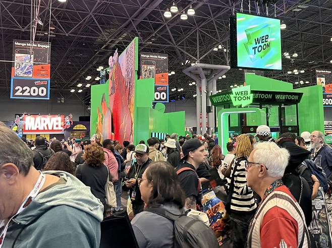 뉴욕 코믹콘 웹툰 엔터 전시관 앞의 관람객 (뉴욕=연합뉴스) 이지헌 특파원 = 9일(현지시간) 미국 뉴욕 자비츠컨벤션센터에서 개막한 뉴욕 코믹콘(NYCC) 2025'의 네이버 웹툰 모회사 웹툰 엔터테인먼트 전시부스 앞에서 관람객들이 북적이고 있다. 2025.10.9 pan@yna.co.kr