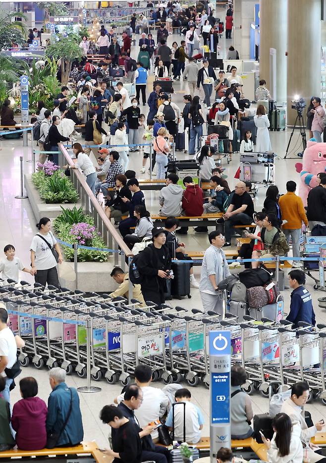 ▲ 12일 인천국제공항 제1여객터미널 입국장이 이용객들로 붐비고 있다. 최장 열흘간의 이번 '추석 황금연휴' 동안 인천국제공항의 하루 평균 이용객이 21만7000명을 기록하며 역대 추석 연휴 중 가장 많은 인파가 몰렸다. /이재민 기자 leejm@incheonilbo.com