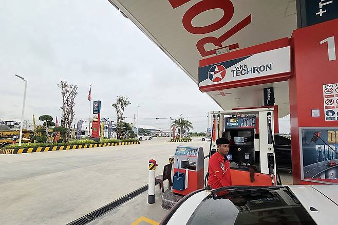 캄보디아 떼쪼 국제공항 인근 주유소 (프놈펜=연합뉴스) 손현규 특파원 = 14일(현지시간) 오후 캄보디아 떼쪼 국제공항 인근 주유소에서 직원이 차량에 기름을 넣고 있다. 2025.10.14 son@yna.co.kr