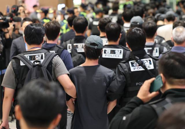 캄보디아 온라인 사기에 가담해 구금된 한국인들이 18일 오전 인천국제공항 제2터미널을 통해 송환되고 있다. 이날 송환에는 경찰 호송조 190여명이 투입됐다. 연합뉴스