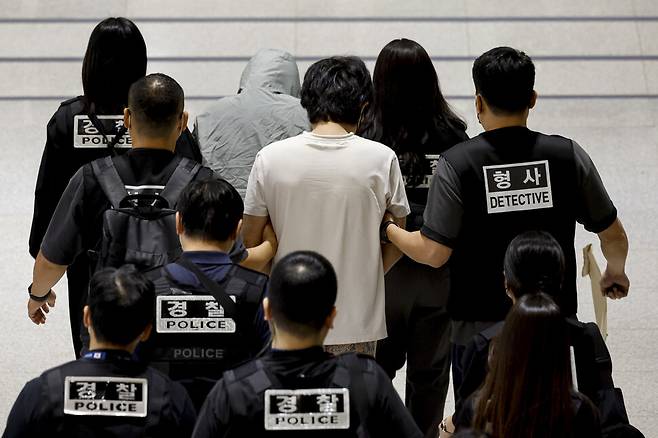 캄보디아 온라인 사기에 가담해 구금된 한국인들이 18일 오전 인천국제공항 제2터미널을 통해 송환되고 있다. 이날 송환에는 경찰 호송조 190여명이 투입됐다. 공동취재사진