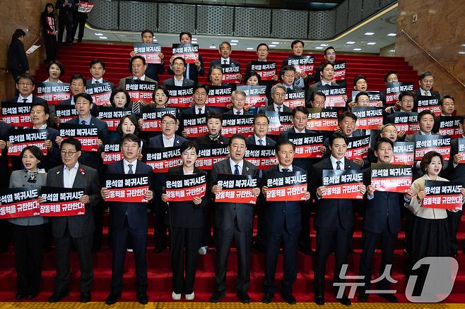 정청래 더불어민주당 대표와 김병기 원내대표를 비롯한 의원들이 20일 서울 여의도 국회 로텐더홀에서 열린 내란수괴 면회 극우선동 장동혁 규탄 기자회견에서 손팻말을 들고 구호를 외치고 있다. 2025.10.20/뉴스1 ⓒ News1 유승관 기자