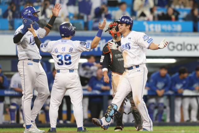 삼성 라이온즈의 김영웅이 22일 대구에서 열린 프로야구 플레이오프 한화 이글스와의 4차전 6회말 동점을 만드는 3점 홈런을 친 뒤 홈으로 들어오자 동료들이 반겨주고 있다. 삼성 제공