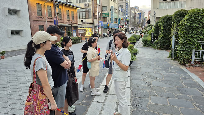 16일 오후 대구 중구청이 운영하는 근대골목 밤마실 투어 참가자들이 대구읍성에 대한 설명을 듣고 있다. 발밑 밝은 회색 돌길이 당시 성벽이 지나갔던 흔적을 표시한 구간이다. 조윤화 기자