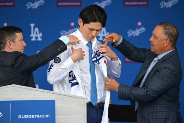 사사키가 지난 1월 23일(한국시각0 다저스 입단식에서 데이브 로버츠 감독(오른쪽), 앤드류 프리드먼 사장의 도움을 받으며 저지를 입고 있다. Imagn Images연합뉴스