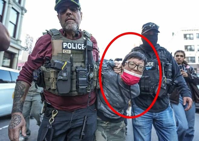 ICE는 21일(현지시간) 오후 가장 오랜 역사를 가진 차이나타운인 맨해튼 차이나타운의 캐널 스트리트를 급습해 노점상을 운영하는 이민자 수 명을 구금했다. 사진은 ICE 요원에게 묶인 채 끌려가는 아시아계 남성