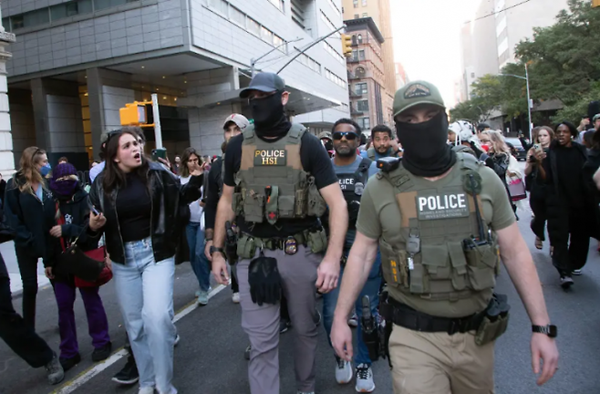 ICE는 21일(현지시간) 오후 가장 오랜 역사를 가진 차이나타운인 맨해튼 차이나타운의 캐널 스트리트를 급습해 노점상을 운영하는 이민자 수 명을 구금했다. 사진은 시민(왼쪽)이 단속 중인 ICE 요원들을 향해 비난하는 모습. 뉴욕포스트 제공