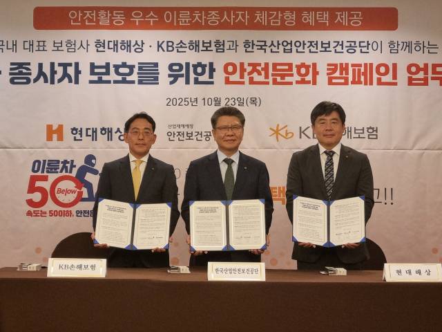 김현중(가운데) 한국산업안전보건공단 이사장이 23일 서울 중구 로얄호텔에서 열린 이륜차 종사자 보호를 위한 업무협약식에서 협약서를 들어 보이고 있다. 사진 제공=안전공단