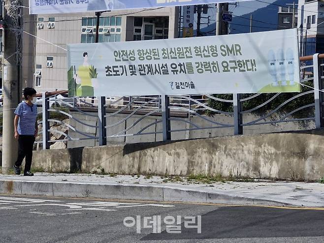 고리 원전에서 가장 가까운 마을인 길천마을의 한 주민이 지난 1일 소규모모듈원전(SMR) 유치를 촉구하는 현수막을 걸어가고 있다. (사진=최훈길 기자)