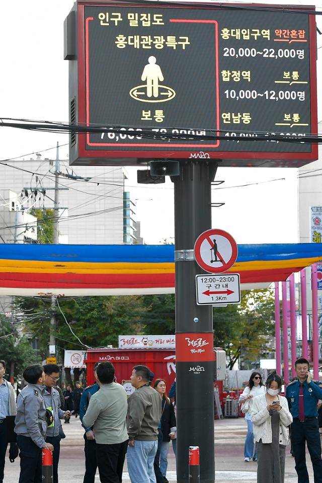 핼러윈데이를 일주일 앞둔 24일 서울시가 주요 인파 밀집 예상 지역 14곳을 대상으로 '특별 안전관리대책'에 가동한 가운데 서울 마포구 홍대축제거리 일대에서 한 경찰이 인구밀집도가 나오는 전광판을 바라보고 있다. 임지훈 인턴기자