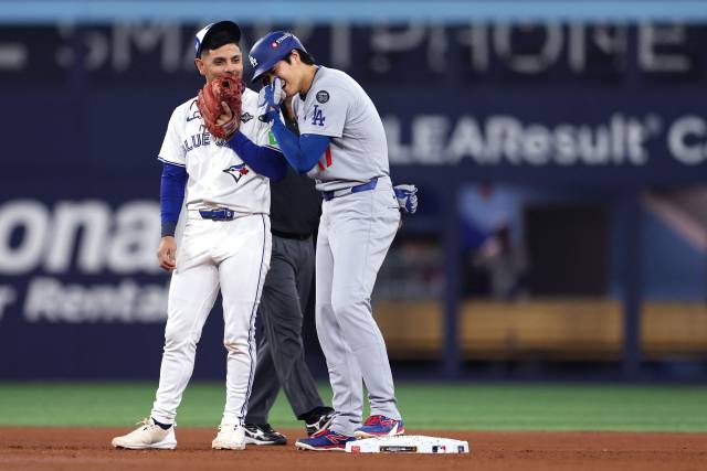 8회 안타를 치고 나간 오타니 쇼헤이(오른쪽)가 후속 타자의 볼넷에 2루를 밟은 뒤 토론토 유격수 안드레 히메네스와 웃으며 얘기하고 있다. AFP연합뉴스