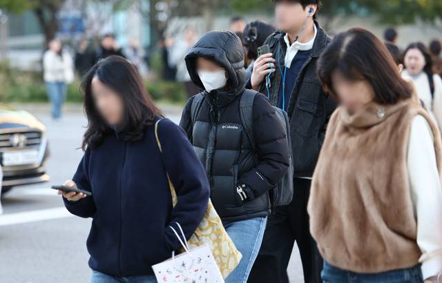 서울 아침 기온이 4도까지 떨어지면서 초겨울 날씨를 보이는 27일 서울 종로구 광화문 세종대로 사거리에서 출근길 시민들이 발걸음을 옮기고 있다. 연합뉴스