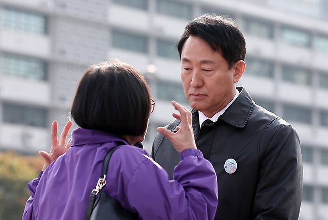 오세훈 서울시장이 29일 서울 종로구 광화문광장에서 열린 10.29 이태원 참사 3주기 기억식에서 유가족 김복순(62)씨에게 항의받고 있다. 공동취재사진