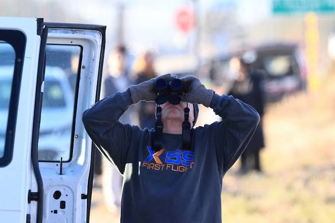 미국 캘리포니아 팜데일 미 공군 제42비행장에서 NASA의 실험용 조용한 초음속기 X-59 퀘스트(Quesst)가 이륙하자 한 남성이 쌍안경으로 그 장면을 지켜보고 있다. 2025년 10월 28일. 로이터 연합뉴스