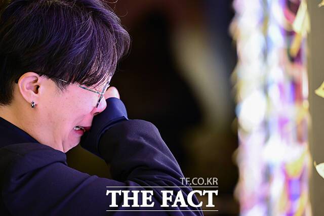 추모 게시판 앞에서 눈물 흘리는 추모객.