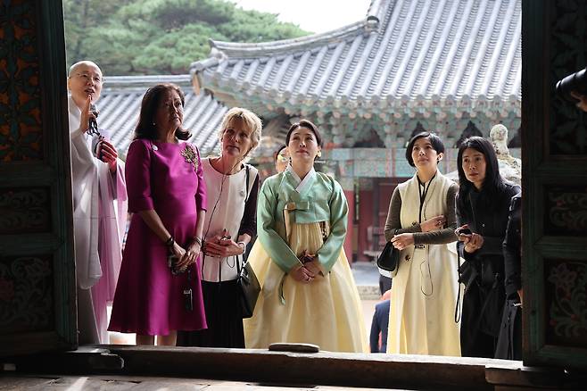 김혜경 여사가 31일 경주 불국사에서 2025 아시아태평양경제협력체(APEC) 정상회의에 참석한 필리핀 루이즈 아라네타 마르코스 여사, 캐나다 다이애나 카니 여사, 대만 총통고문 딸 린원쉬안 씨, 싱가포르 루츠루이 여사 등 각국 정상 배우자들과 함께 대웅전에 대한 설명을 듣고 있다. 연합