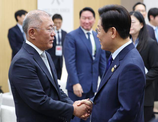 이재명 대통령이 지난달 31일 경북 경주 경주화백컨벤션센터에서 열린 젠슨 황 엔비디아 최고경영자(CEO)와의 접견 당시 참석한 정의선(왼쪽) 현대차그룹 회장을 맞이하고 있다. 경주=연합뉴스