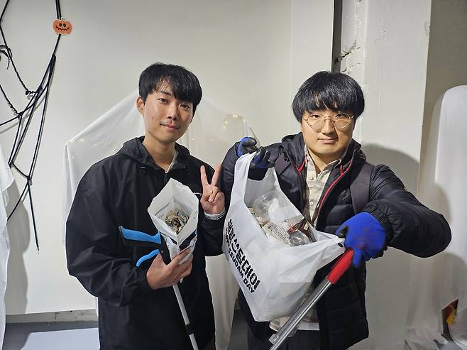 지난달 31일 서울 홍대입구역 일대에서 진행된 ‘해피쓰담데이’ 캠페인에 참여한 김대교(오른쪽) 씨와 조형준 씨가 기념 촬영을 하고 있다. 김광우 기자.